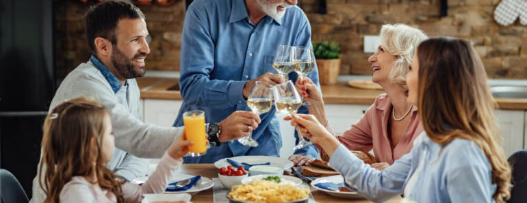 Happy extended family enjoying in a lunch and toasting at dining table